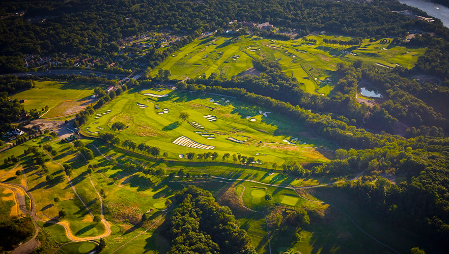 Aerial photograph overlooking a golf course during a sunset.