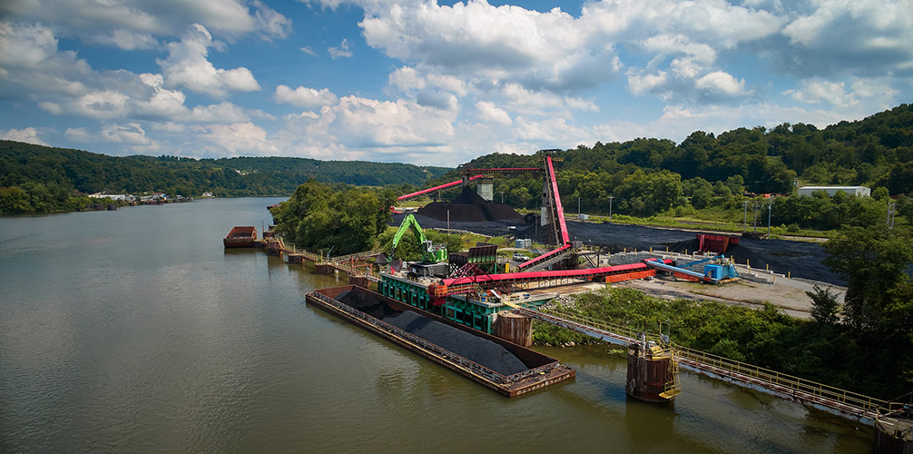 Aerial photograph of coal being loaded onto a barge.