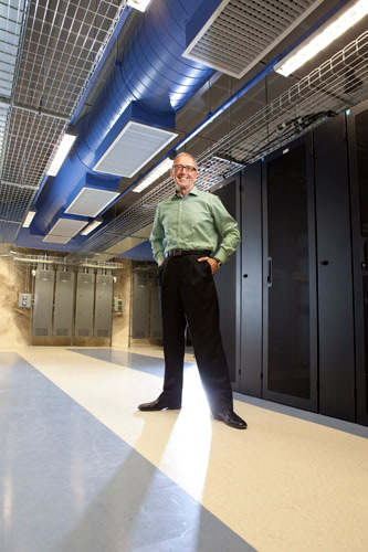Man standing in front of a collection of servers.