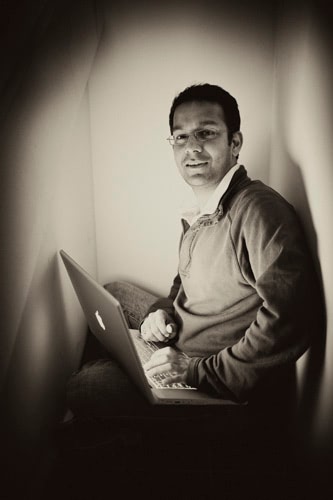 Black and white photo of a man on his laptop.
