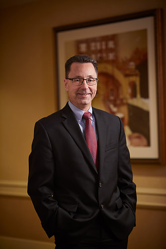 Portrait of a man in a black suit.